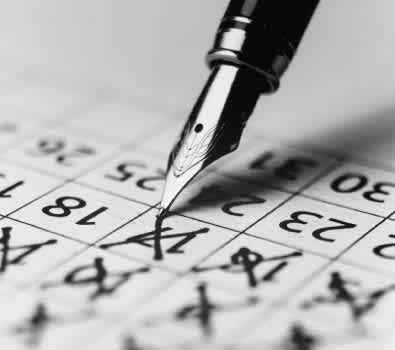 A pen crossing out dates on a calendar