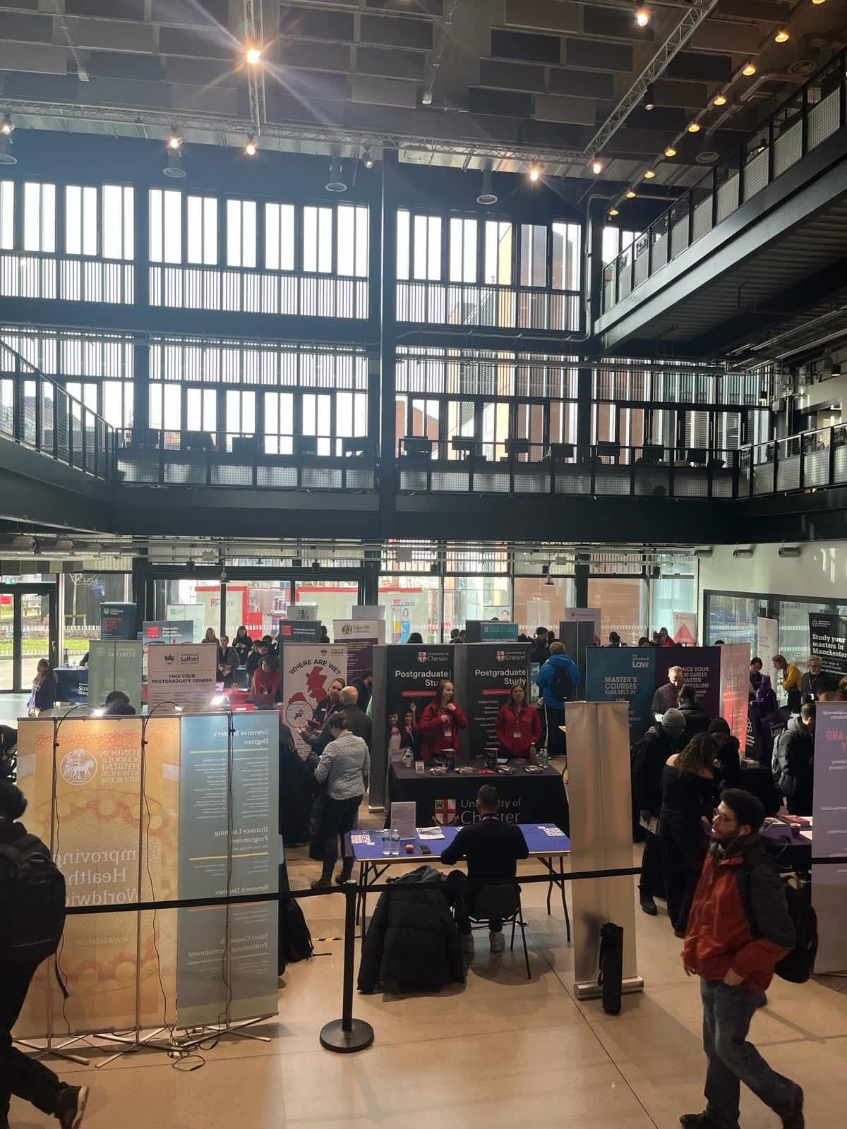 Students speaking with university exhibitors at Postgrad LIVE