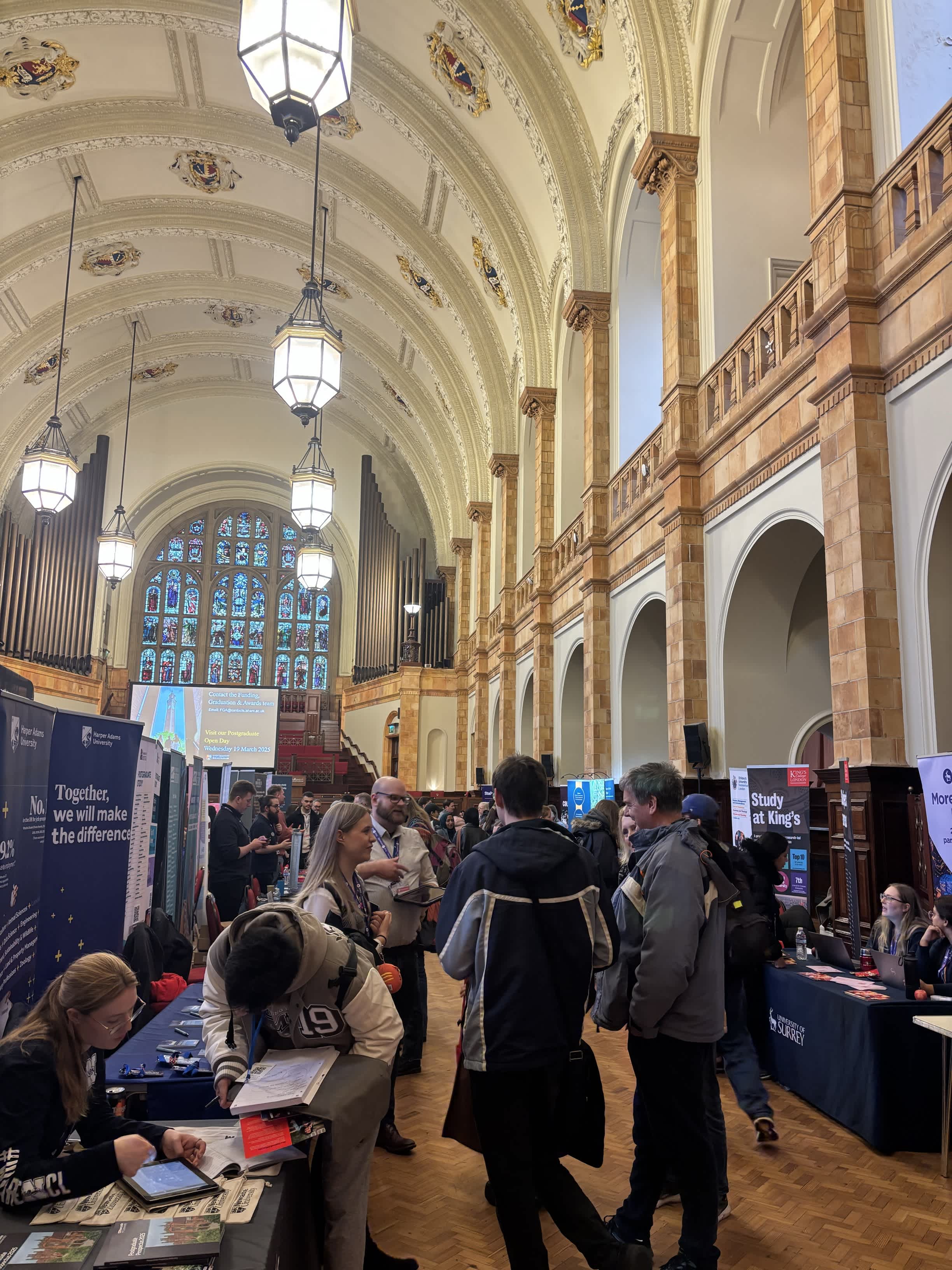 Students speaking with university exhibitors at Postgrad LIVE
