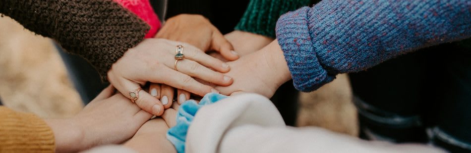 Eight hands placed on top of one another