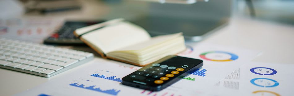 Calculator, notebook and charts on a table