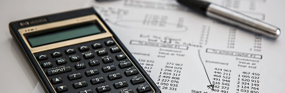 Calculator, notebook and charts on a table