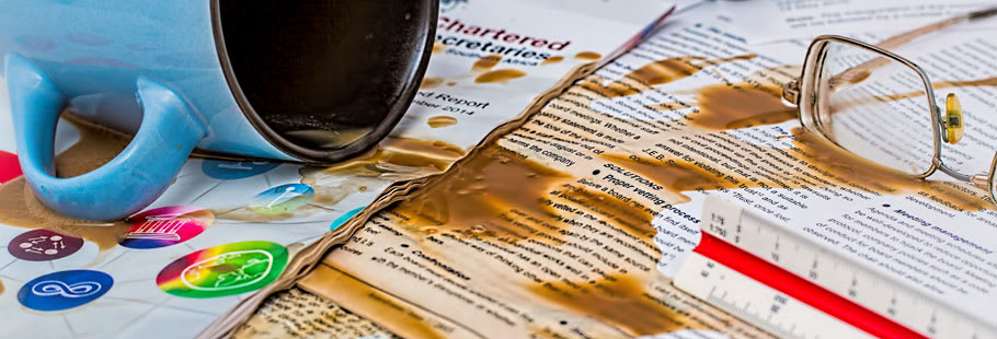 Cup of coffee spilled on paperwork Cup of coffee spilled on paperwork