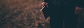Someone holding a book outside