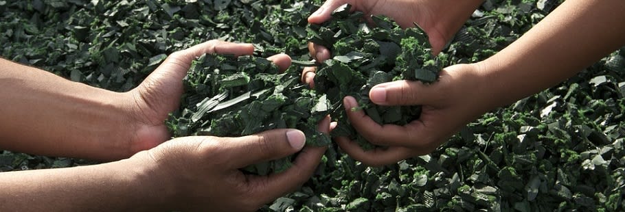 Hands with recycled green rubber