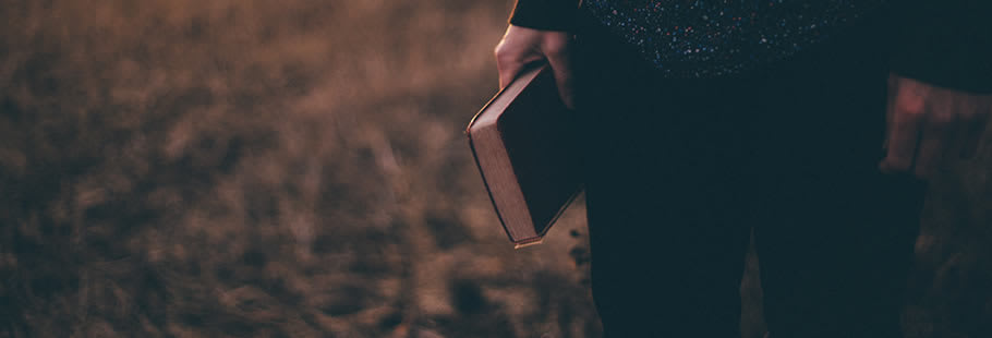 Womans hand carrying leather-bound book