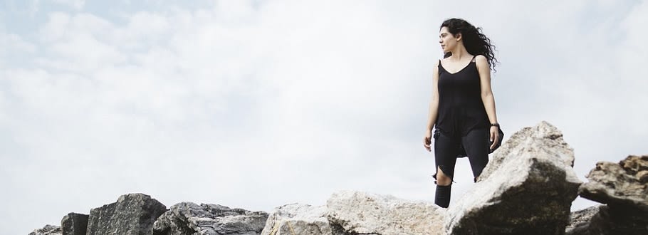 Front shot of girl stood on top of rocks looking out