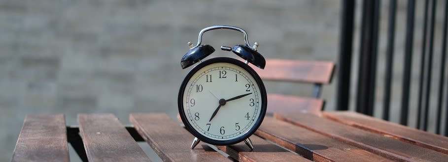 An old fashioned alarm clock on a wooden table