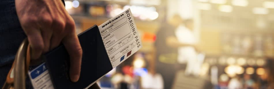 Close up of a boarding pass with blurred background of airport