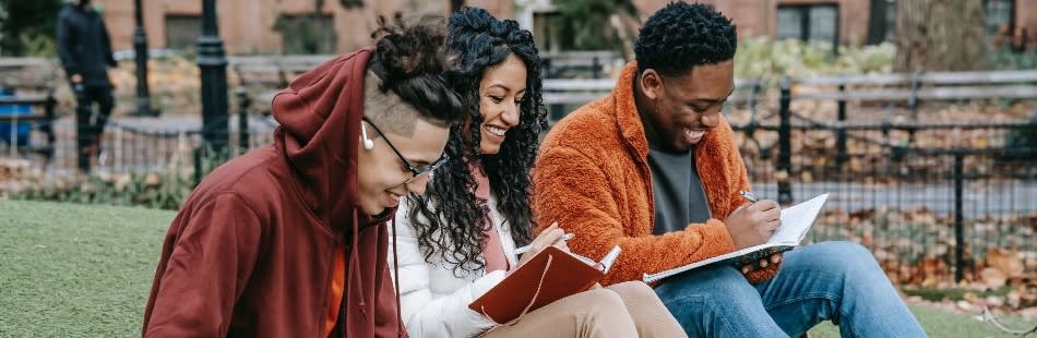 Three Masters students studying outside