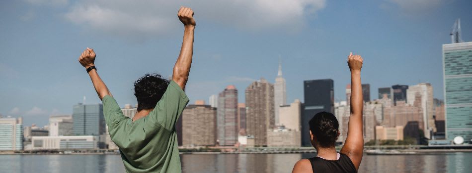 Two people punching the air with city skyline Two people punching the air with city skyline