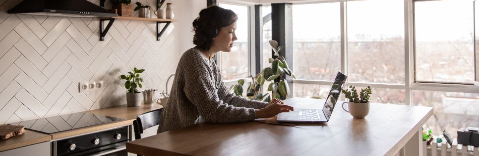 Woman at kitchen table with laptop