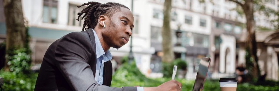 Man sat outside with laptop on table