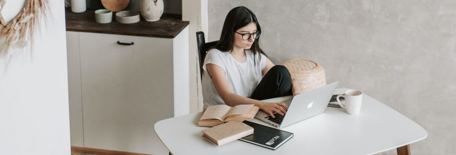 Dark haired woman on laptop in kitchen