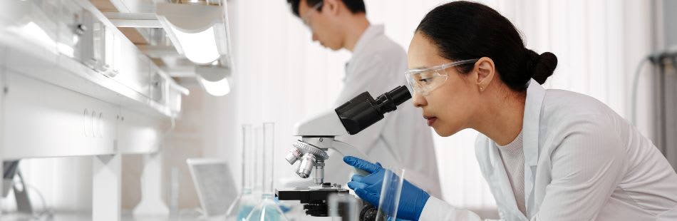 Female scientist looking through microscope